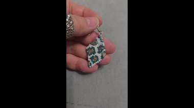 Hafif arka planda el yapımı boncuklu ve cam boncuklu küpeler. Ürün gösterisi. Moda trendleri. Boşluğu kopyala