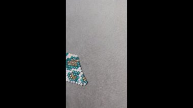 Hafif arka planda el yapımı boncuklu ve cam boncuklu küpeler. Ürün gösterisi. Moda trendleri. Boşluğu kopyala