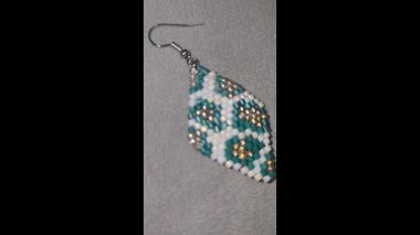 Hafif arka planda el yapımı boncuklu ve cam boncuklu küpeler. Ürün gösterisi. Moda trendleri. Boşluğu kopyala