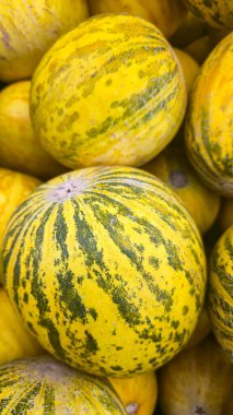 Raflardaki büyük sandıklarda yuvarlak sarı karpuzlar. Meyve sergisi ve satışı. Süpermarketten alışveriş..