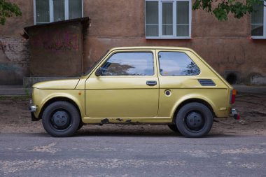 City Riga, Letonya. Retro Fiat 126 sokak, altın renk. Kentsel şehir manzaralı. 2018.