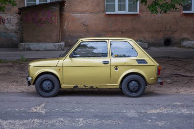 City Riga, Letonya. Retro Fiat 126 sokak, altın renk. Kentsel şehir manzaralı. 2018.