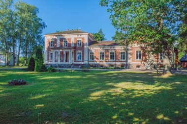 Şehir Taurene, Letonya. Eski malikane ve çayır, yeşil ağaçlar. Seyahat fotoğraf 2018.