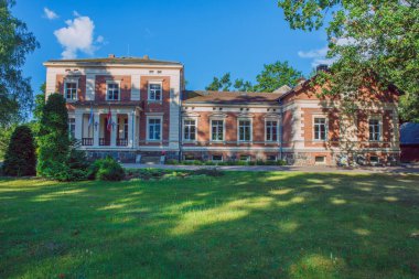 Şehir Taurene, Letonya. Eski malikane ve çayır, yeşil ağaçlar. Seyahat fotoğraf 2018.