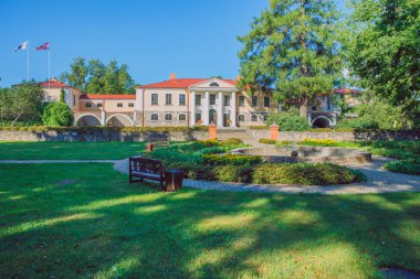 Şehir Vecpiebalga, Letonya. Eski malikane ve çayır, yeşil ağaçlar. Seyahat fotoğraf 2018.