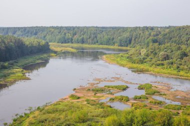 Şehir Kraslava, Letonya. Güneş ışığı, nehir ve ağaçlar erken sabaha. Su ile doğa fotoğraf. Seyahat fotoğraf 2018.