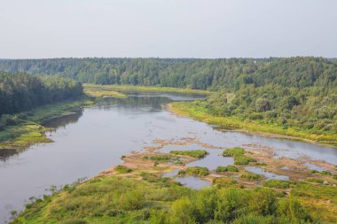 Şehir Kraslava, Letonya. Güneş ışığı, nehir ve ağaçlar erken sabaha. Su ile doğa fotoğraf. Seyahat fotoğraf 2018.