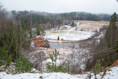 Şehir Cesis, Letonya, nehir Amata. Kırmızı kayalıklarla ve kışın nehir. Kar ve kayalar, seyahat fotoğraf 2018. 30. Aralık.