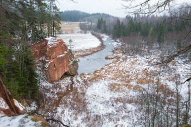 Şehir Cesis, Letonya, nehir Amata. Kırmızı kayalıklarla ve kışın nehir. Kar ve kayalar, seyahat fotoğraf 2018. 30. Aralık.