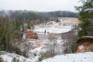 Şehir Cesis, Letonya, nehir Amata. Kırmızı kayalıklarla ve kışın nehir. Kar ve kayalar, seyahat fotoğraf 2018. 30. Aralık.