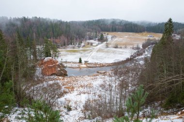 Şehir Cesis, Letonya, nehir Amata. Kırmızı kayalıklarla ve kışın nehir. Kar ve kayalar, seyahat fotoğraf 2018. 30. Aralık.