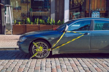 Riga, Letonya. Eski şehir sokak ve kilitli araba SIMIDI, bmw. Güneşli kış günü. Seyahat kentsel fotoğraf 2019, 21 Şubat.