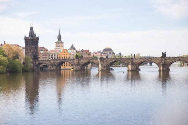 Old Charles bridge and buildings. Vltava river with glare. Trave