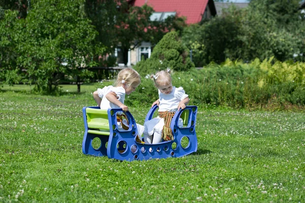 Város Cesis, a Lett Köztársaság. Két kislány ül egy Swin — Stock Fotó
