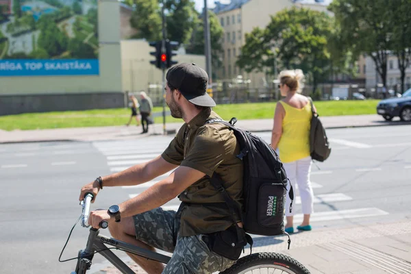 Miasto Ryga, Republika Łotewska. Rowerzysta zatrzymał się na czerwonym ruchu LIGH — Zdjęcie stockowe