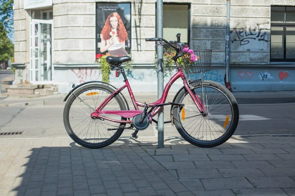 Staden Riga, lettiska republiken. En röd cykel parkeras på stre- — Stockfoto