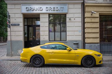 City Riga, Latvian Republic. Yellow ford Mustang on the street.  clipart