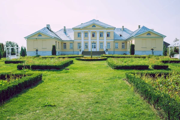 Ciudad Brukna, República de Letonia. Parque con antigua mansión. Árboles y género — Foto de Stock
