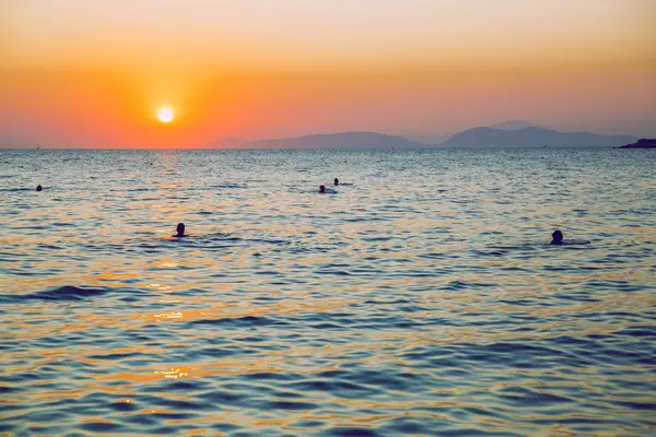 République grecque. Soleil dans la mer et les gens qui nagent. Dans le dist — Photo