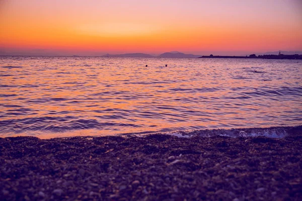 República Griega. El sol en el mar y la gente nadando. En el dist — Foto de Stock