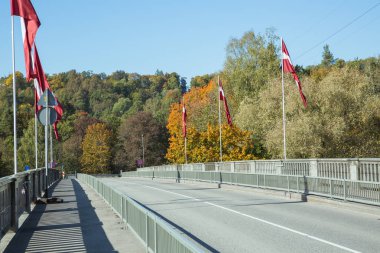Şehir Sigulda, Letonya Cumhuriyeti. Au bayraklı nehir ve köprü