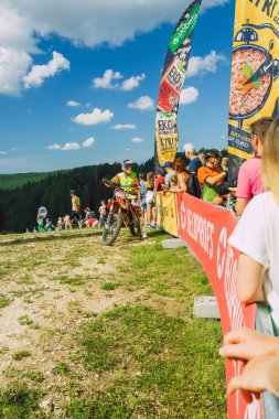 Bir dağ üzerinde ülkeyi boydan boya geçen bir motosiklet. Dağda güneşli bir gün. 09.08.2020