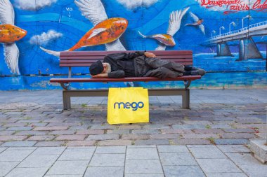 Daugavpils Şehri, Letonya. Bankta uyuyan evsiz bir adam. Seyahat fotoğrafı. 11.08.2020