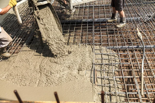 Pouring concrete into the construction of the house