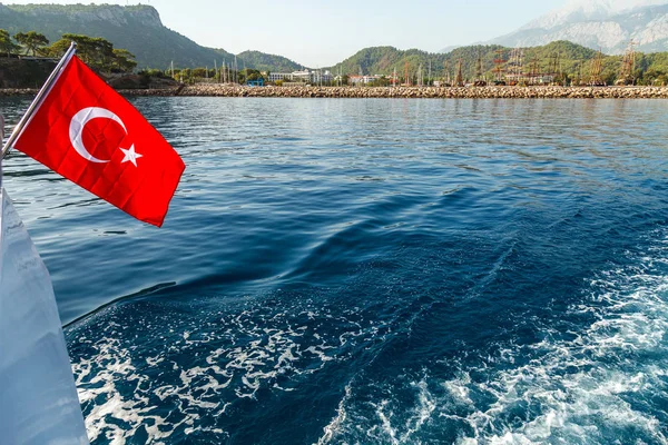 Beyaz bir hilal ve yıldız ile kırmızı bir Türk bayrağı rüzgara karşı inanılmaz bir deniz manzara fon tarafından geliştirmektedir. Akdeniz ve Türkiye sahillerinde içinde belgili tanımlık geçmiş