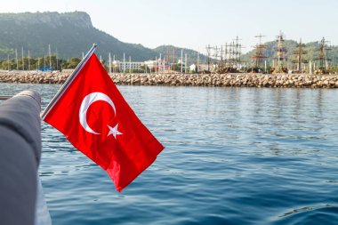 Beyaz bir hilal ve yıldız ile kırmızı bir Türk bayrağı rüzgara karşı inanılmaz bir deniz manzara fon tarafından geliştirmektedir. Akdeniz ve Türkiye sahillerinde içinde belgili tanımlık geçmiş