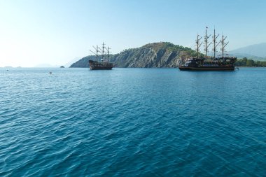 Zevk korsan gemisi Akdeniz dağ eteklerinde, kıyı şeridi boyunca yelken turist