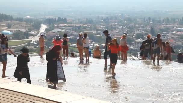 Pamukkale, Turquía, 15 de octubre de 2018, un gran número de turistas se encuentran en la terraza superior de travertinos de piedra caliza blanca — Vídeo de stock