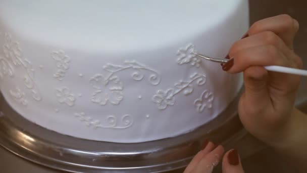Cukiernik rysuje kremowe kwiaty na białym torcie weselnym — Wideo stockowe