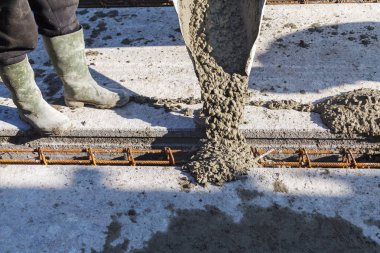 İşçiler Mobil Beton karıştırıcı kullanarak bir konut bina inşaatı için temel dökme