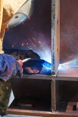 Bir fabrikada kaynak işçisi. Endüstriyel bir tesisi üzerinde kaynak.