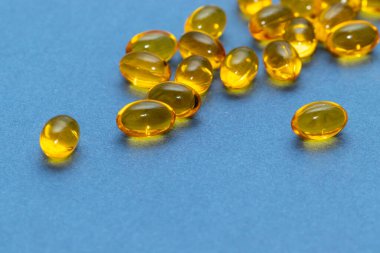 Kapsüller balık yağı sarı uyku mavi arka plan