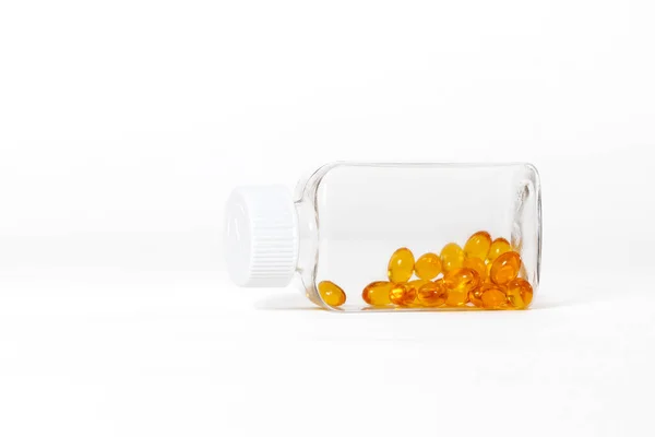 白色底色玻璃瓶中的黄色鱼油胶囊 — 图库照片
