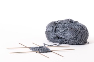 Dört örgü iğnesine örmeye başla. Örgü yün ve örgü iğneleri beyaz arka planda izole edilmiş..