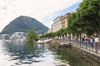 Lugano, İsviçre - 12 Mayıs 2018: Bulutlu bahar sabahı Lake Lugano yakınındaki bir şehir set olduğunu.