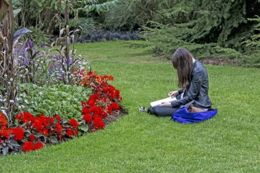 London, Büyük Britanya - 17 Eylül 2014: Tanımlanamayan genç sanatçı doğanın bir kroki sonbahar parkta yapar..