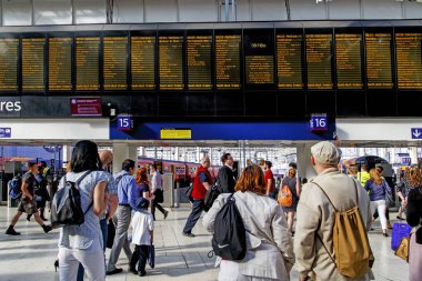 London, Büyük Britanya - 19 Mayıs 2014: Waterloo istasyonu platformları Uçus tarifesi tahtaya önünde kimliği belirsiz insanlar bunlar.