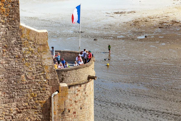 MONT SAINT MICHEL, FRANCE - 2 Eylül 2019 Bunlar Kraliyet Kulesi üzerindeki Fransa bayrağıyla birlikte alçak gelgitte körfezin üzerinde yükselen şehir tahkimatları..
