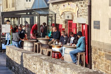 SAINT-MALO, FRANCE - 4 Eylül 2019 'da sakinler, kentin kale duvarına bitişik tarihi bir binada bulunan küçük kafenin tadını çıkarıyorlar..