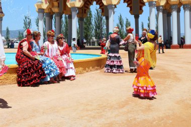 CORDOBA, İspanya - 23 Mayıs 2017: Renkli ulusal elbiseli tanımlanamayan kadınlar Feria festival sahasında fotoğraf çekiyorlar.