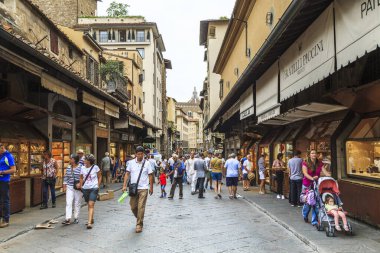 FLORENCE, ITALY - 13 Eylül 2018: Kimliği belirsiz turist ve sakinler Ponte Vecchio 'dan geçerek, sayısız hediyelik eşya dükkanının önünden geçtiler.