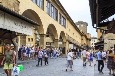 FLORENCE, ITALY - 13 Eylül 2018: Kimliği belirsiz turist ve sakinler Ponte Vecchio 'dan geçerek, sayısız hediyelik eşya dükkanının önünden geçtiler.