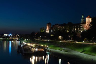 Kale Wawel - bir tepe ve Krakow, Polonya, Vistula sol yakasında mimari bir kompleks. Kale Wawel akşam ışık Köprüsü'nden görüntülemek. 