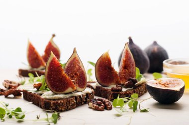 Krem peynir ve beyaz zemin üzerine incir parçaları ile sandviçler. Sağlıklı ve lezzetli ev yapımı yiyecek