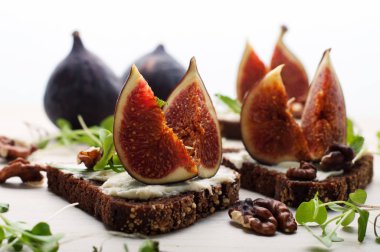 Krem peynir ve beyaz zemin üzerine incir parçaları ile sandviçler. Sağlıklı ve lezzetli ev yapımı yiyecek