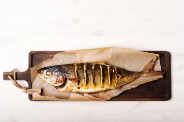 Limon tuna (deniz balığı) kahverengi kesme tahtası üzerinde ile pişmiş. Beyaz arka plan. Görüntünün en üstündeki metin için yer